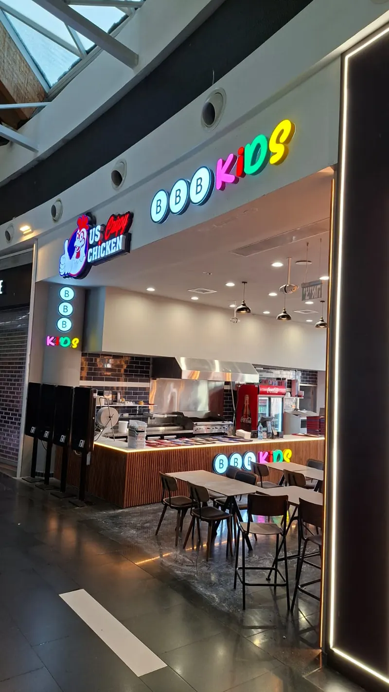 Letras de canal iluminadas frontales en la entrada de una tienda — rótulos BBB Kids y US Crispy Chicken