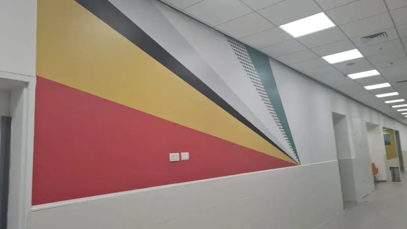 Mural de pared geométrico con triángulos coloridos en pasillo — SignWorks