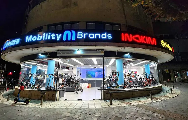 Rótulo circular iluminado Mobility Brands en edificio redondo — SignWorks