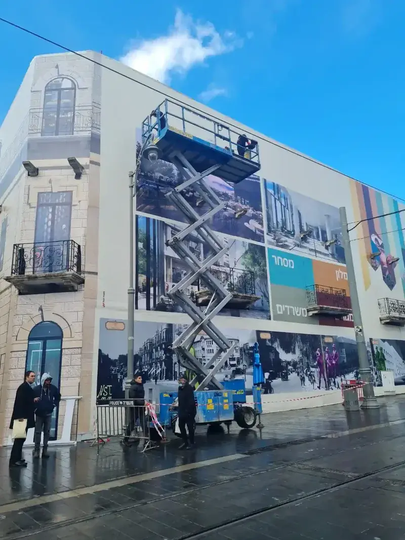 Trabajadores en plataforma elevadora instalando vinilado de edificio — SignWorks