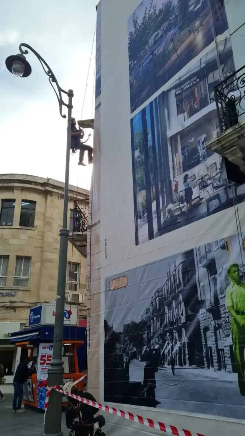 Trabajador en acceso por cuerda instalando gran póster en edificio — SignWorks