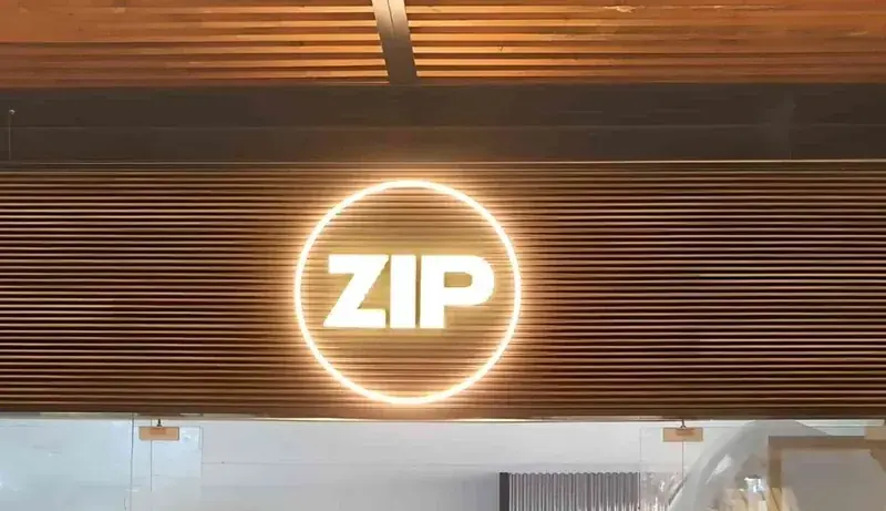 ZIP LED neon illuminated sign on wooden background